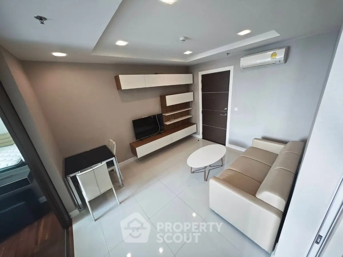 Modern living room with sleek furniture and wall-mounted TV in a stylish apartment.