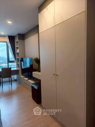 Modern living room with city view, sleek furniture, and ample storage space.