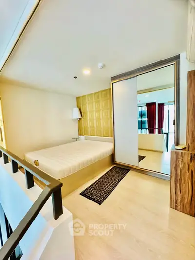 Modern bedroom with stylish decor and mirrored wardrobe in a contemporary apartment.