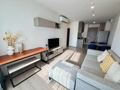 Modern living room with stylish decor, cozy seating, and natural light in a contemporary apartment.