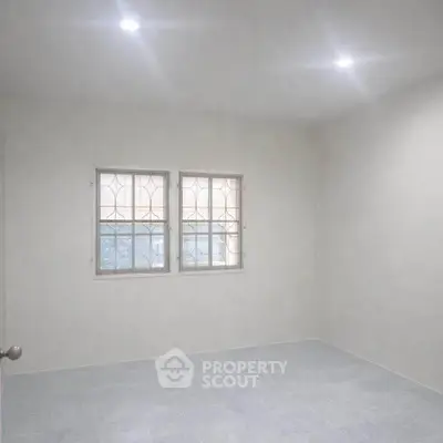 Spacious empty room with tiled floor and two windows, ideal for customization.