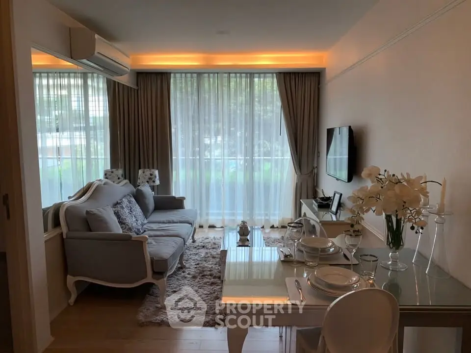 Elegant living room with modern decor, large windows, and stylish furniture in a cozy apartment.