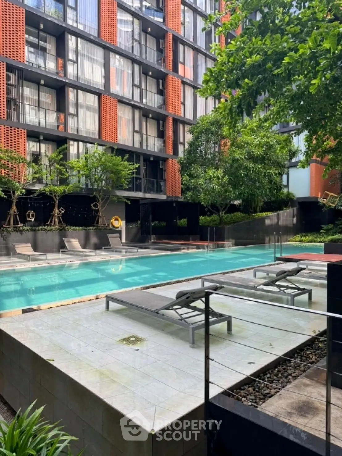 Modern apartment complex with luxurious pool and lush greenery