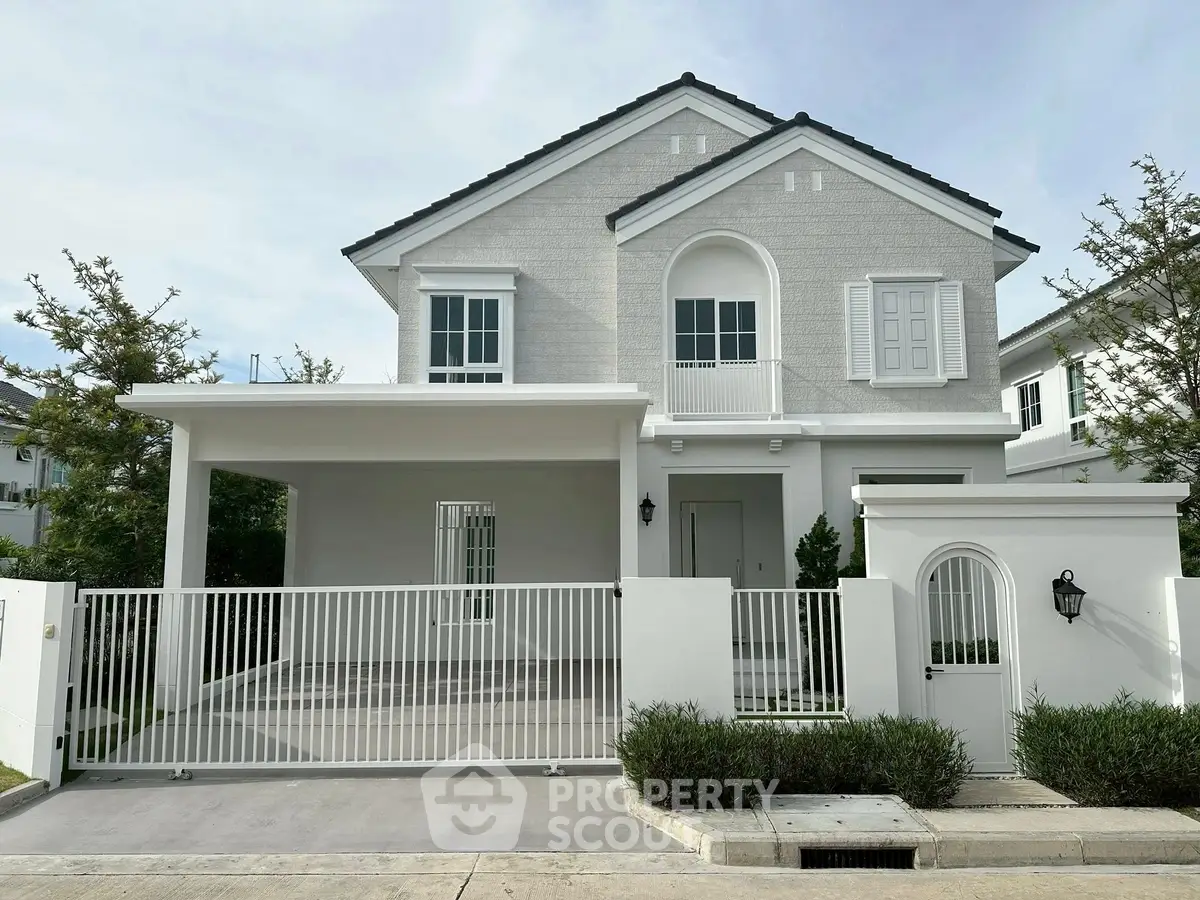 Charming two-story house with modern facade and gated driveway in serene neighborhood.
