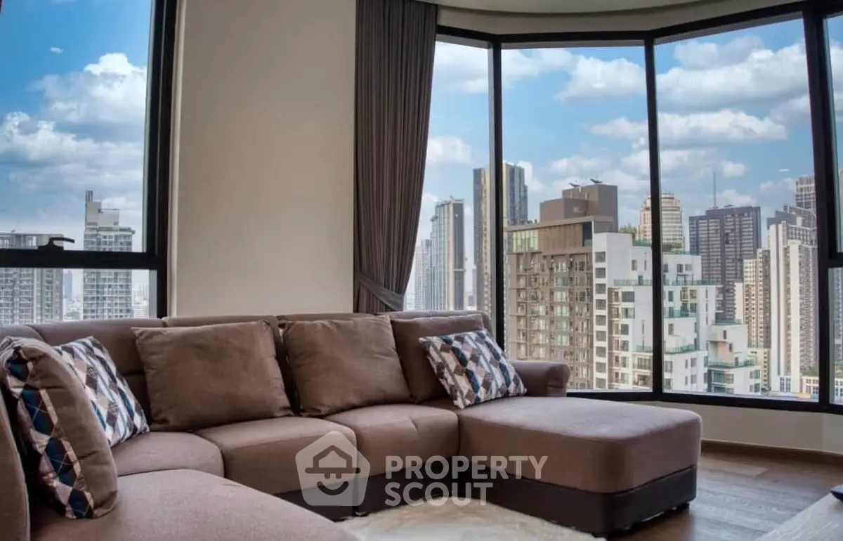 Spacious living room with panoramic city view and modern sectional sofa.
