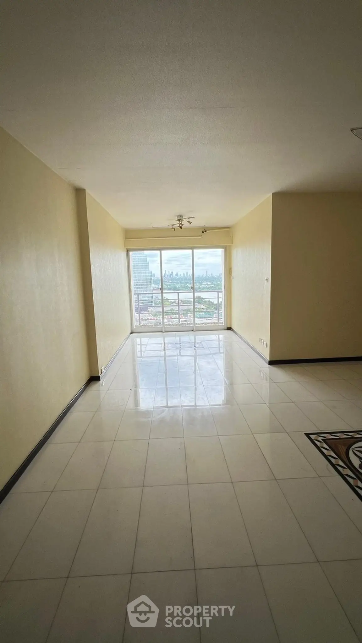 Spacious living room with large windows offering a stunning city view, perfect for modern living.