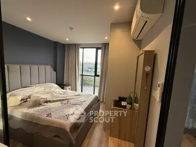Cozy bedroom with modern decor and large window offering scenic views.