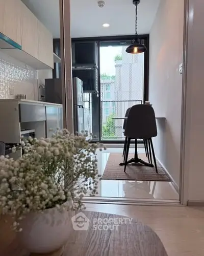 Modern kitchen with sleek design and open layout, featuring dining area and large window with natural light.
