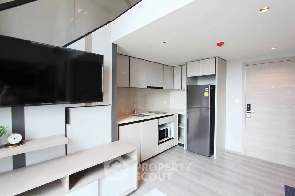Modern kitchen with sleek cabinetry and stainless steel appliances in a stylish apartment.