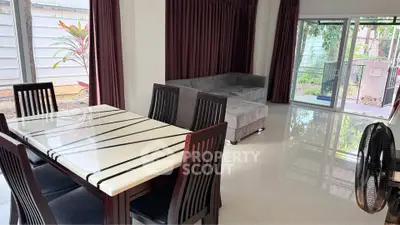 Spacious living room with modern dining area and large windows for natural light.