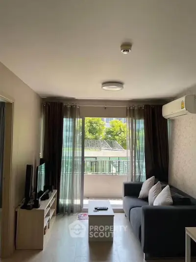 Charming living room with cozy sofa and large window offering natural light and greenery view.