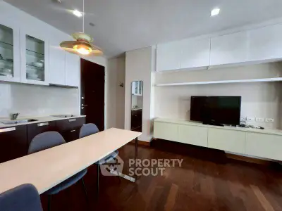 Modern living room with sleek furniture and open layout, featuring a stylish dining area and entertainment center.