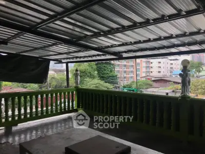 Spacious covered balcony with city view, perfect for relaxation and outdoor gatherings.