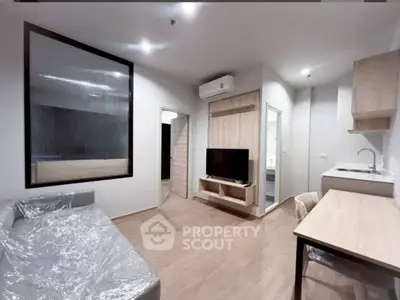 Modern living room with sleek furniture and open kitchen layout in a stylish apartment.