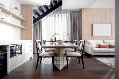 Modern dining area with elegant decor and natural light in a stylish open-plan living space.