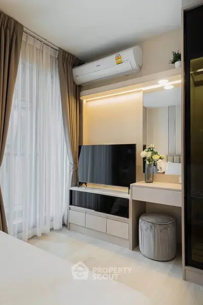 Modern bedroom with sleek design, featuring a wall-mounted TV, air conditioning, and elegant decor.