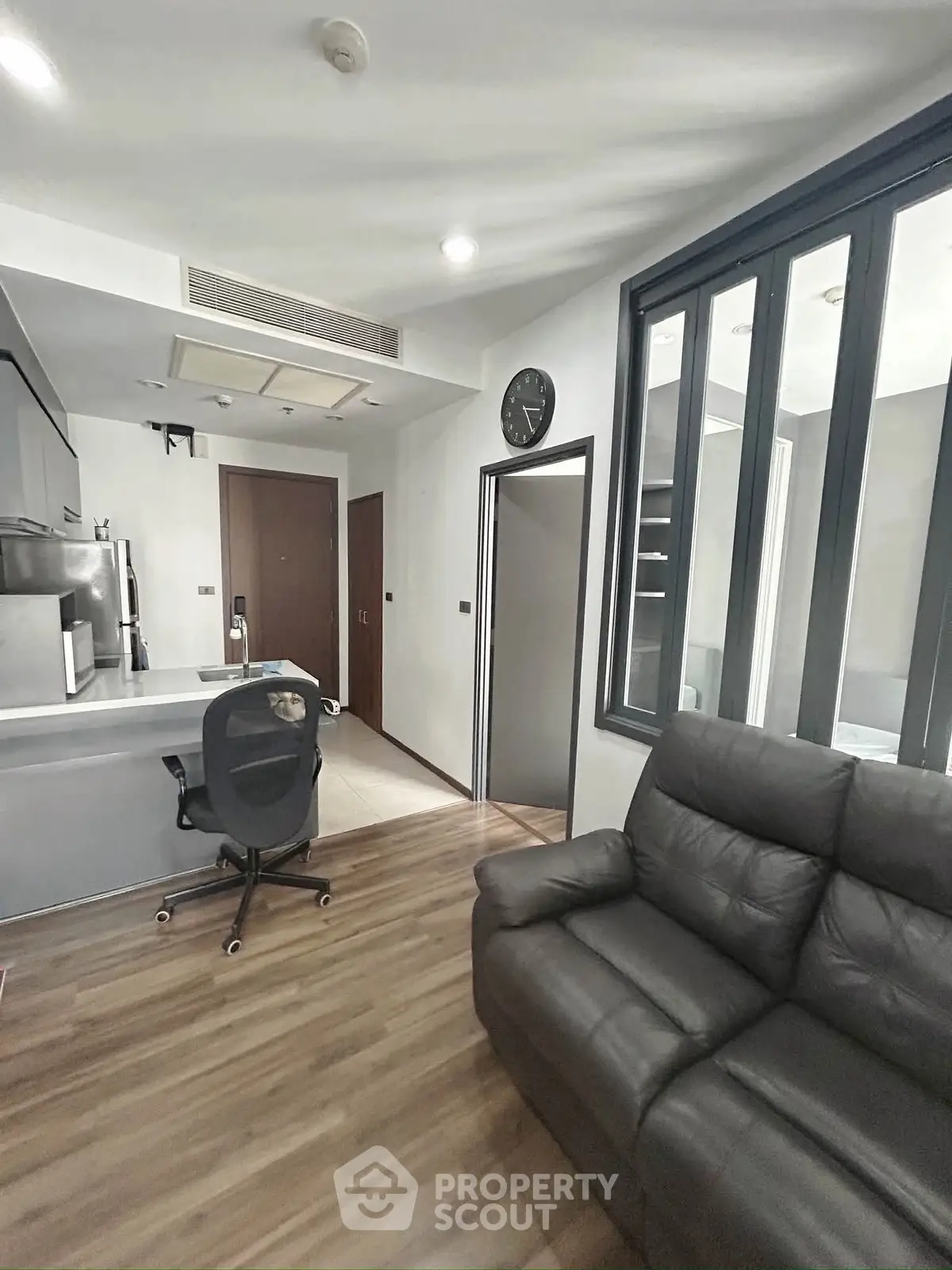 Modern living room with sleek furniture and open kitchen layout in a stylish apartment.