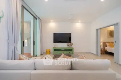 Spacious living room with modern decor and sliding doors leading to a cozy bedroom.