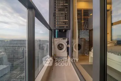 Modern high-rise balcony with washing machine and stunning city view