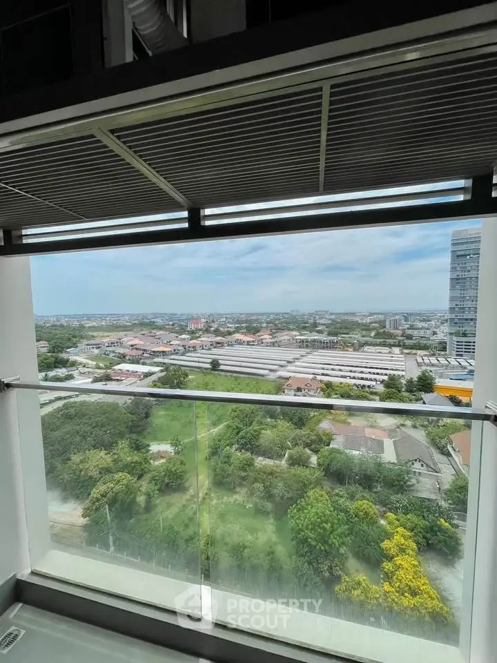 Stunning high-rise balcony view with expansive cityscape and lush greenery.