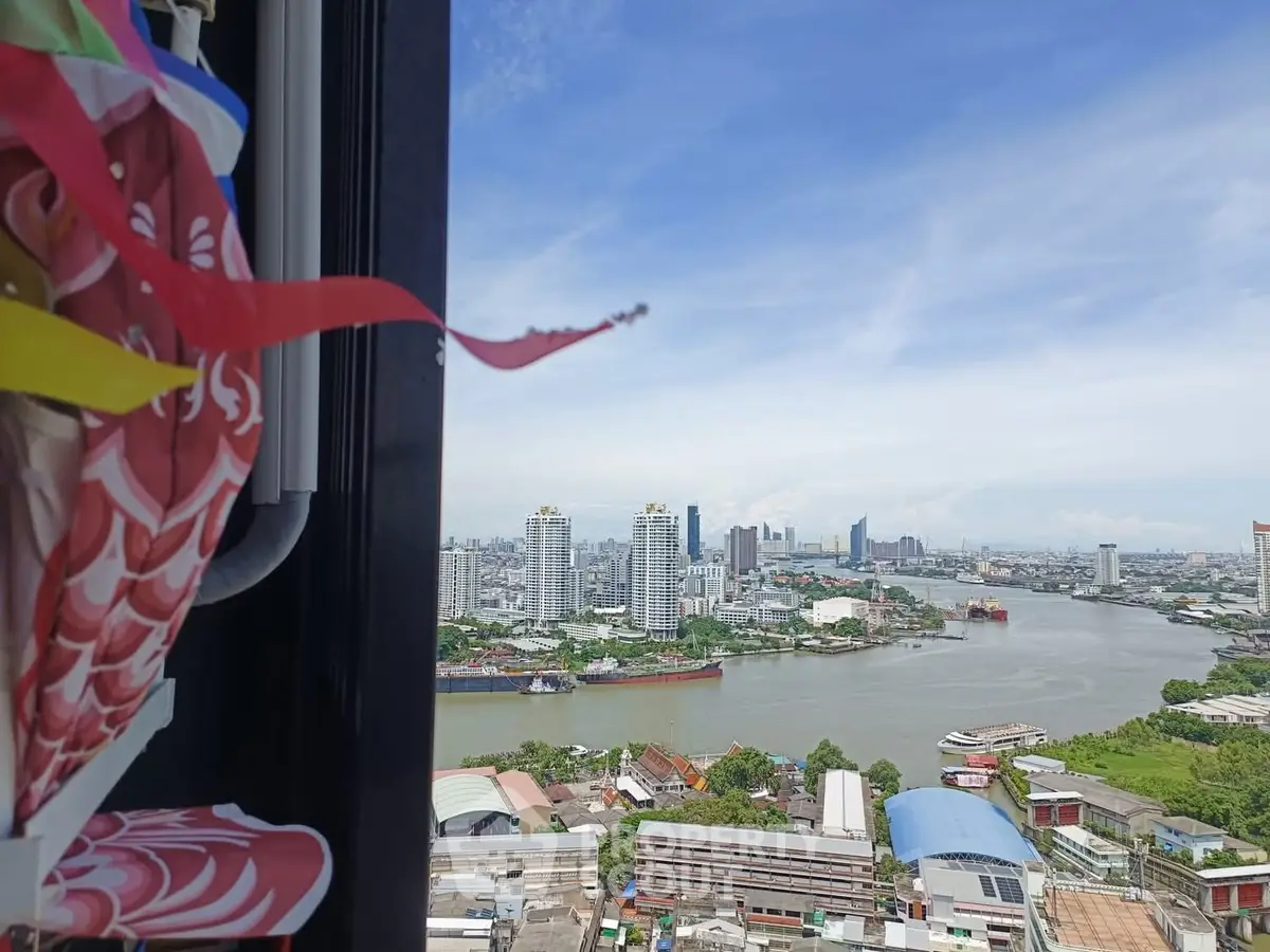 Stunning cityscape view from high-rise apartment window overlooking river and skyline.