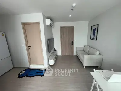 Modern living room with minimalist decor, featuring a cozy sofa, wall-mounted TV, and stylish flooring.