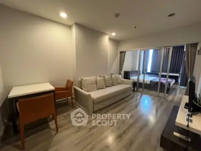 Modern living room with cozy sofa and dining area in open-plan apartment