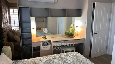 Chic bedroom with stylish vanity, modern decor, and ample storage in a cozy apartment.