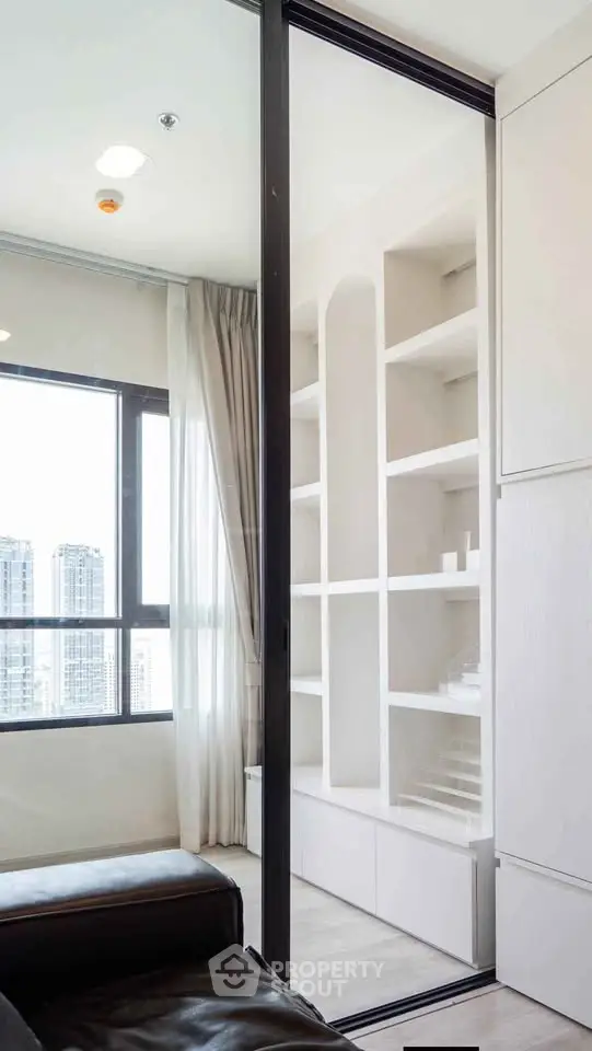Modern living room with large windows and built-in shelving, offering a bright and airy atmosphere.
