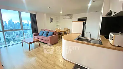 Spacious open-plan living room with city view, modern kitchen, and cozy dining area in high-rise apartment.