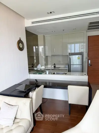 Modern open-layout kitchen with sleek cabinetry and dining area in a stylish apartment.