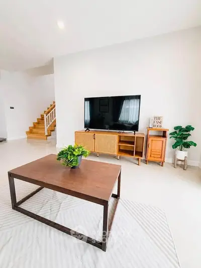Modern living room with stylish furniture and large TV, perfect for relaxation.