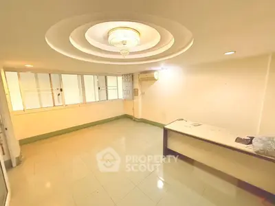 Spacious office room with modern ceiling design and ample natural light.