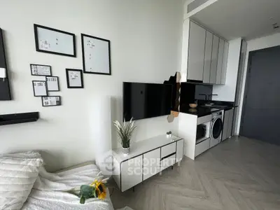 Modern studio apartment with sleek kitchen and cozy living area, featuring stylish decor and compact appliances.