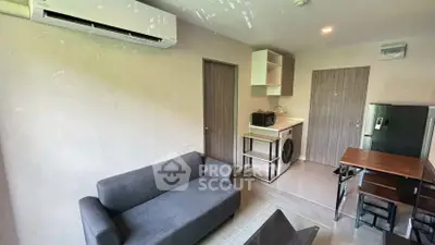 Modern living room with compact kitchen and washing machine, ideal for urban living.