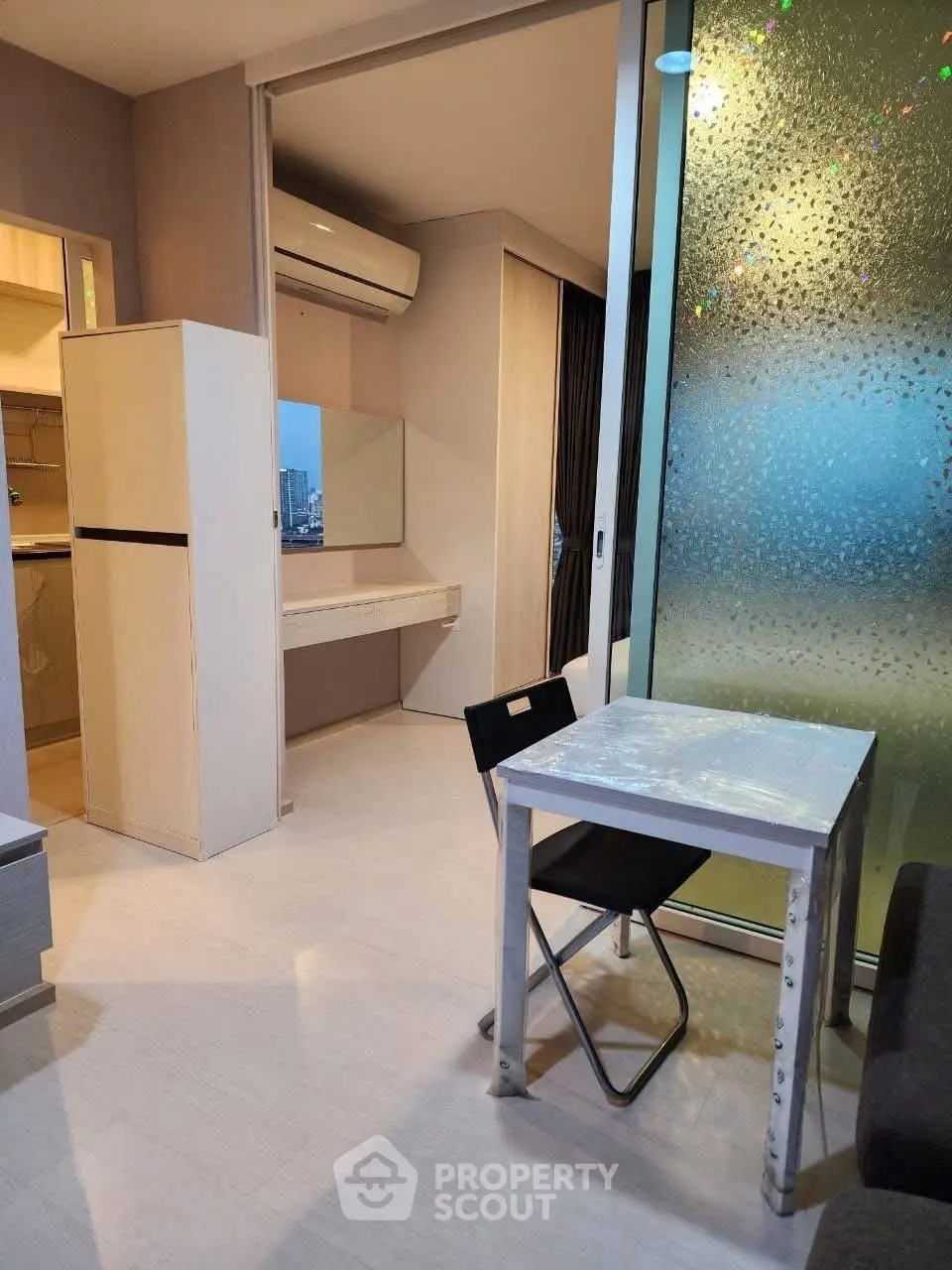 Modern apartment interior with compact dining area and city view.