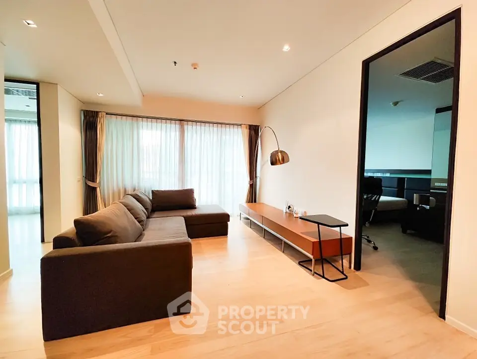 Spacious modern living room with large windows and elegant furniture in a stylish apartment.