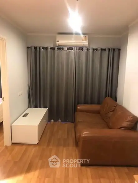 Cozy living room with leather sofa and air conditioning, perfect for relaxation.
