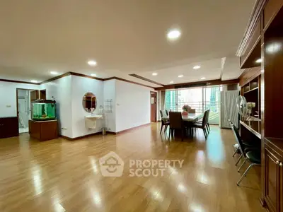Spacious open-plan living and dining area with wooden flooring and city view.