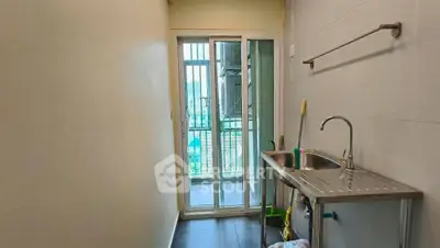 Compact utility area with sink and balcony access in modern apartment.