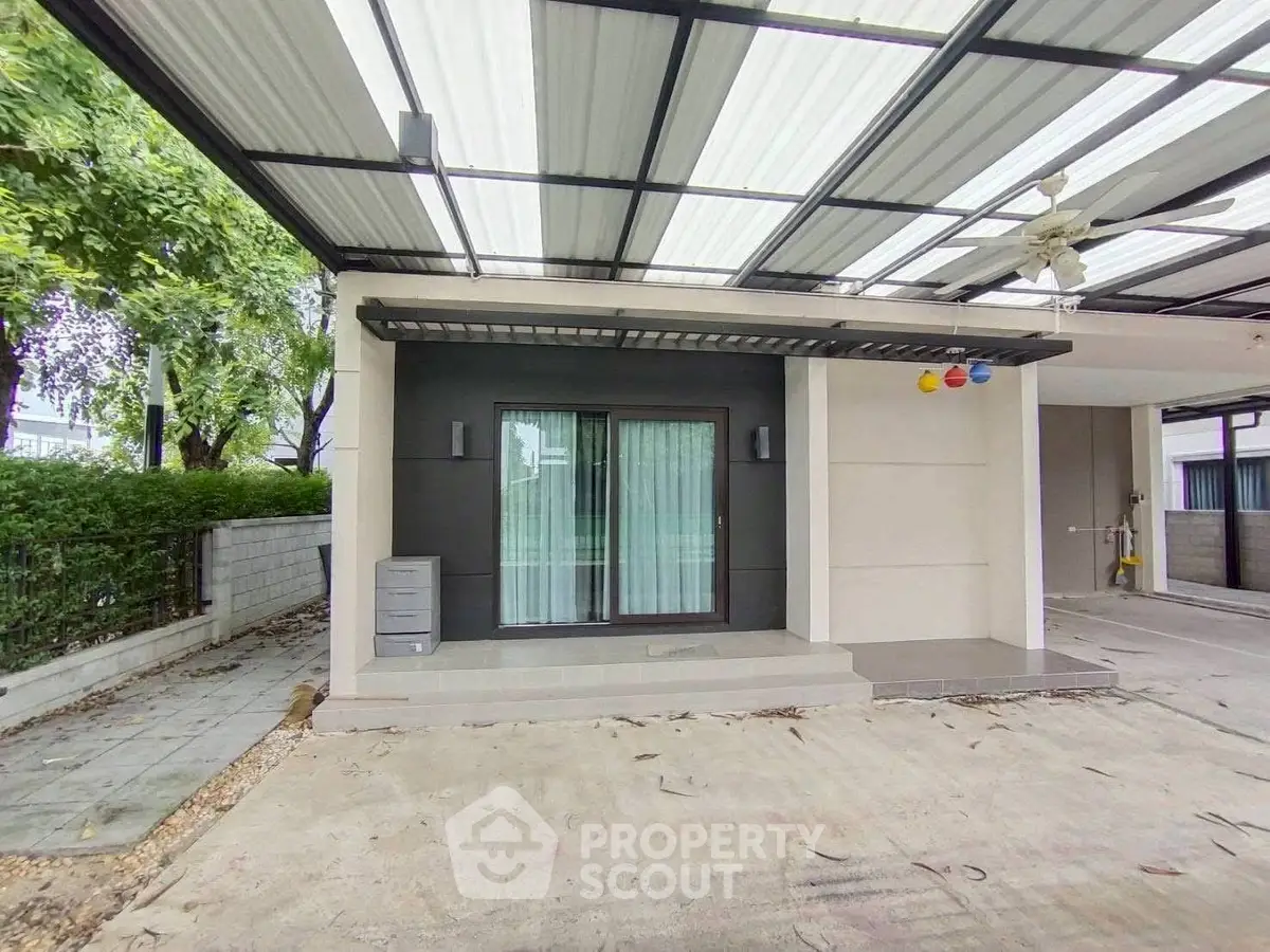 Modern covered parking area with sliding glass doors and ceiling fan