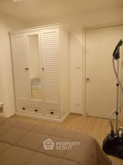 Cozy bedroom with wardrobe and steam iron, perfect for modern living.