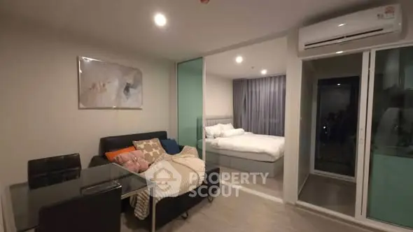 Modern studio apartment with cozy living area and bedroom, featuring sleek furniture and ambient lighting.