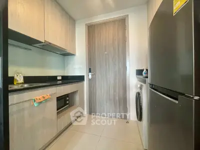 Modern kitchen with sleek appliances and wooden cabinetry in a stylish apartment.
