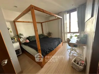 Cozy bedroom with wooden four-poster bed and natural light from large window.
