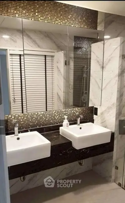 Luxurious modern bathroom with dual sinks and elegant marble finishes.