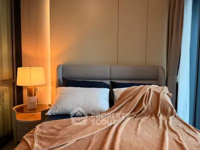 Cozy bedroom with elegant lighting and plush bedding in modern apartment.