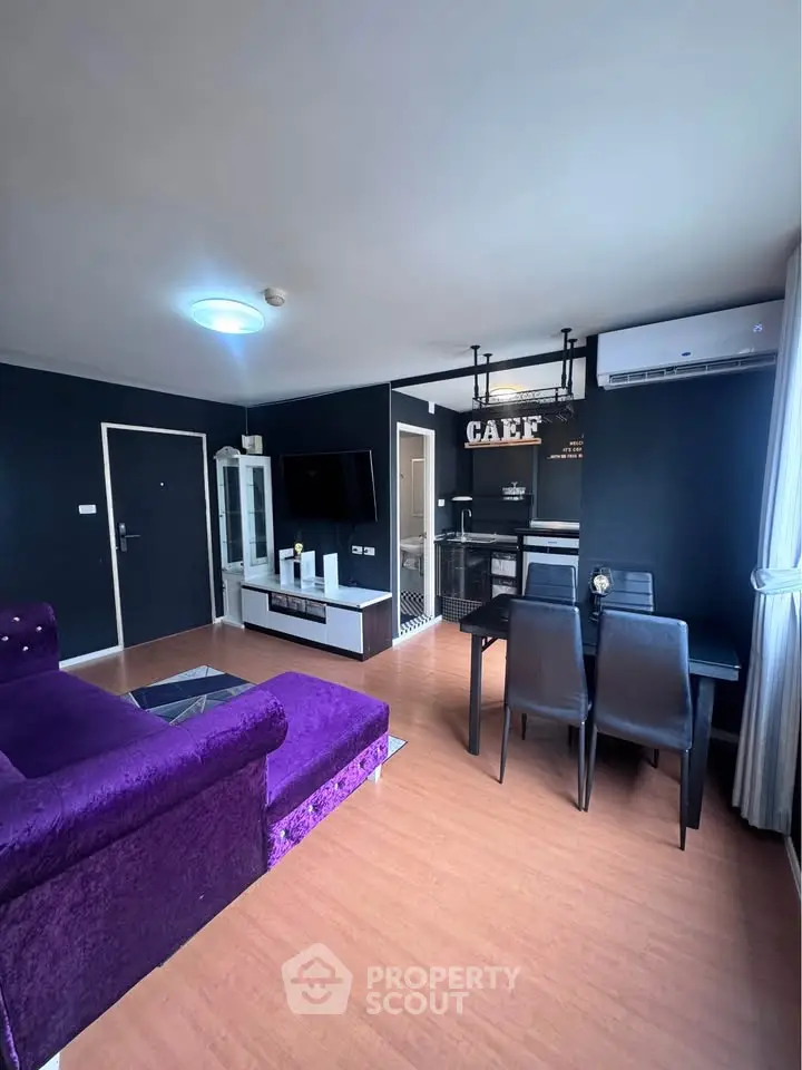 Stylish modern living room with purple sofa and dining area in open layout apartment.