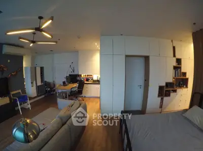 Modern living room with stylish lighting and integrated workspace in a cozy apartment.