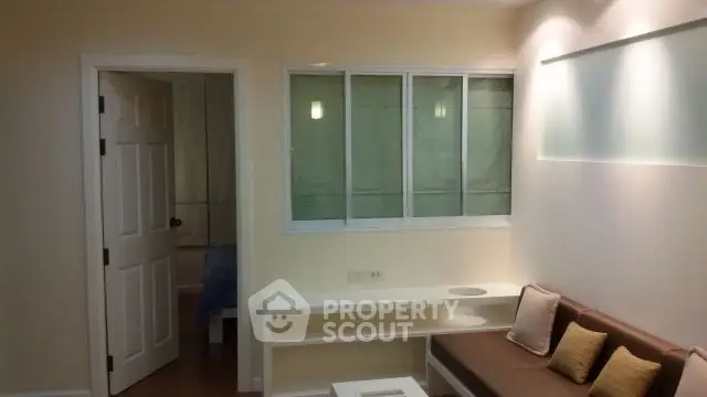 Cozy living room with modern lighting and a glimpse into the bedroom, perfect for urban living.